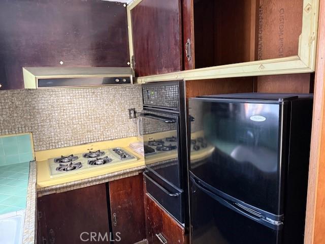 2208 W Olympic Blvd, Montebello, CA 90640 - kitchen with black appliances, tasteful backsplash, light countertops, and range hood