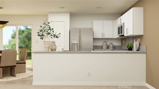 7594 Taylor Ave, Hesperia, CA 92345 - kitchen with white fridge with ice dispenser, stainless steel microwave, white cabinetry, a peninsula, and plenty of natural light