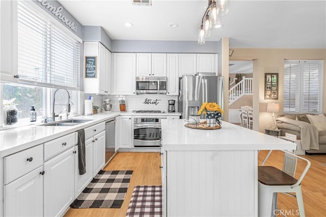 25525 Fitzgerald Ave, Stevenson Ranch, CA 91381 - kitchen with stainless steel appliances, open floor plan, and white cabinets