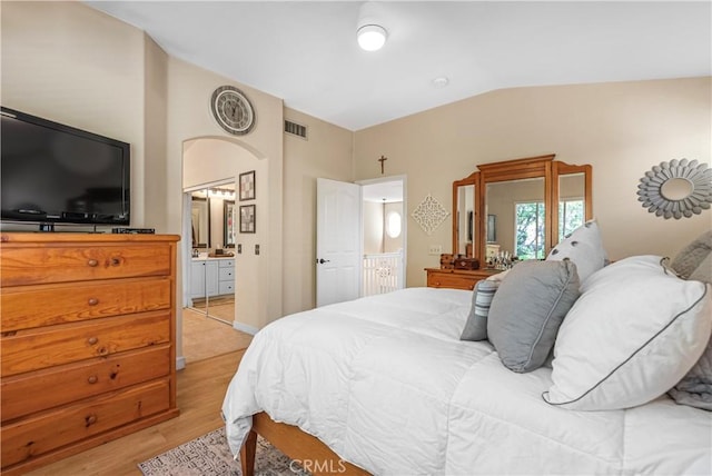 25525 Fitzgerald Ave, Stevenson Ranch, CA 91381 - bedroom featuring vaulted ceiling, light wood-type flooring, arched walkways, and ensuite bathroom