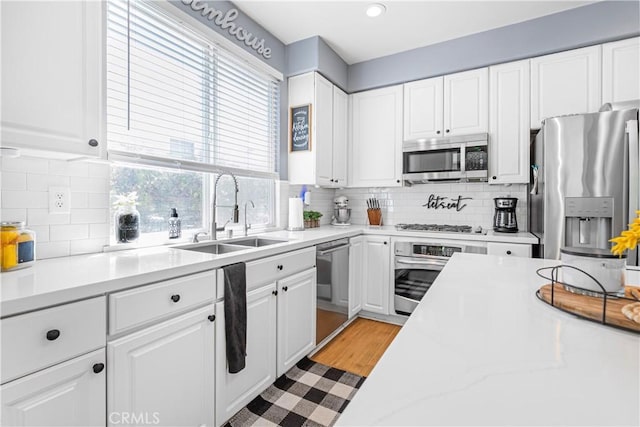 25525 Fitzgerald Ave, Stevenson Ranch, CA 91381 - kitchen featuring stainless steel appliances, white cabinets, backsplash, light countertops, and recessed lighting