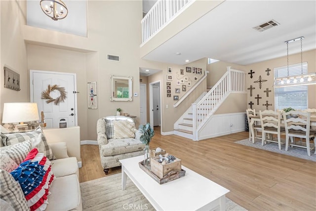 25525 Fitzgerald Ave, Stevenson Ranch, CA 91381 - living area featuring a chandelier, wood finished floors, stairway, and a wainscoted wall