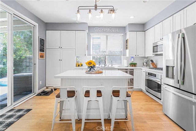 25525 Fitzgerald Ave, Stevenson Ranch, CA 91381 - kitchen with stainless steel appliances, white cabinetry, light countertops, light wood-style flooring, and recessed lighting