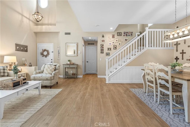 25525 Fitzgerald Ave, Stevenson Ranch, CA 91381 - living area with stairway, wood finished floors, a chandelier, and a towering ceiling