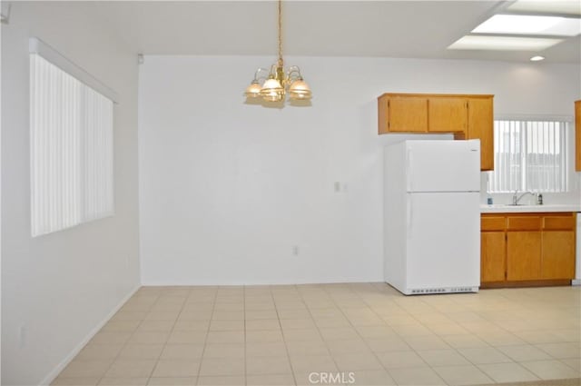 856 Liam Way, Beaumont, CA 92223 - kitchen with freestanding refrigerator, light countertops, a chandelier, and brown cabinets