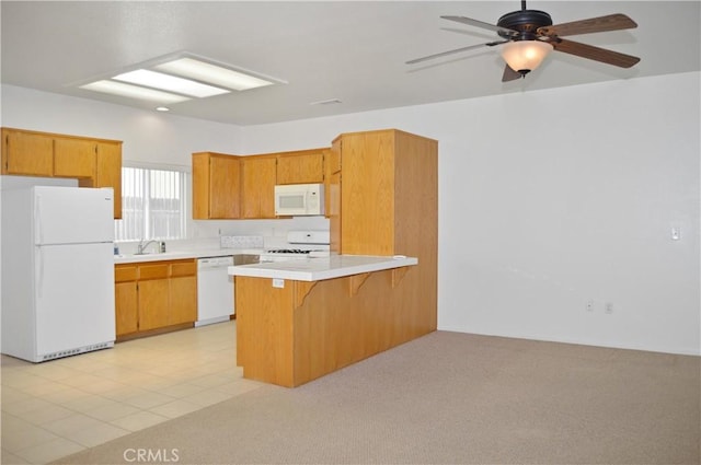 856 Liam Way, Beaumont, CA 92223 - kitchen with white appliances, a peninsula, a ceiling fan, a kitchen breakfast bar, and brown cabinets