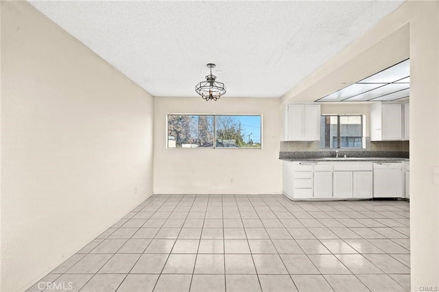 11331 Elliott Ave Unit 21, El Monte, CA 91732 - kitchen with dishwasher, white cabinetry, dark countertops, a textured ceiling, and light tile patterned floors