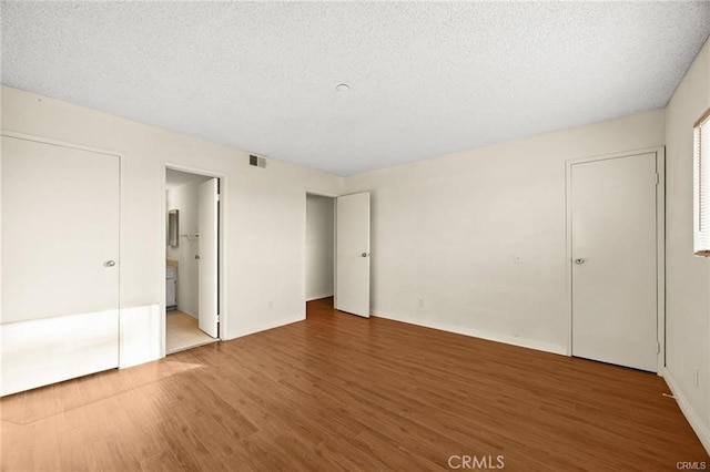 11331 Elliott Ave Unit 21, El Monte, CA 91732 - unfurnished bedroom with wood finished floors, ensuite bathroom, and a textured ceiling