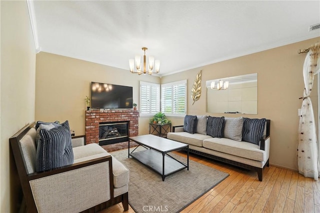 19121 Broken Bow Dr, Riverside, CA 92508 - living area with a chandelier, light wood finished floors, crown molding, and a brick fireplace