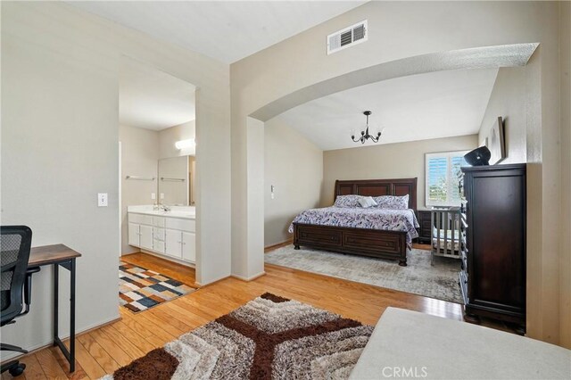 19121 Broken Bow Dr, Riverside, CA 92508 - bedroom featuring wood finished floors, a chandelier, arched walkways, and ensuite bathroom