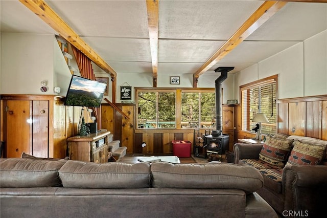 833 Brier Trl, Big Bear Lake, CA 92315 - living room with a wood stove, wooden walls, a wainscoted wall, and beam ceiling