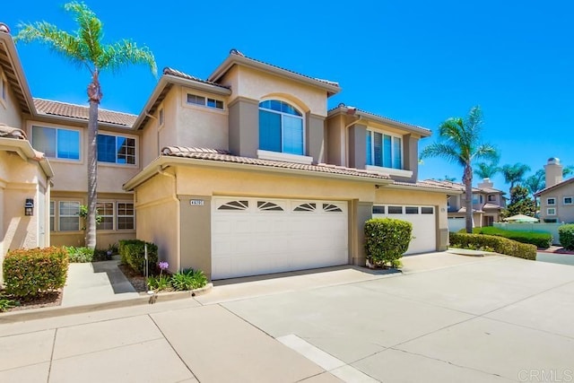 4620 Los Alamos Way Unit C, Oceanside, CA 92057 - mediterranean / spanish home featuring an attached garage, stucco siding, driveway, and a tile roof
