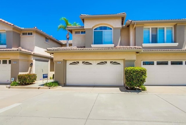 4620 Los Alamos Way Unit C, Oceanside, CA 92057 - mediterranean / spanish-style home with an attached garage, stucco siding, concrete driveway, and a tile roof