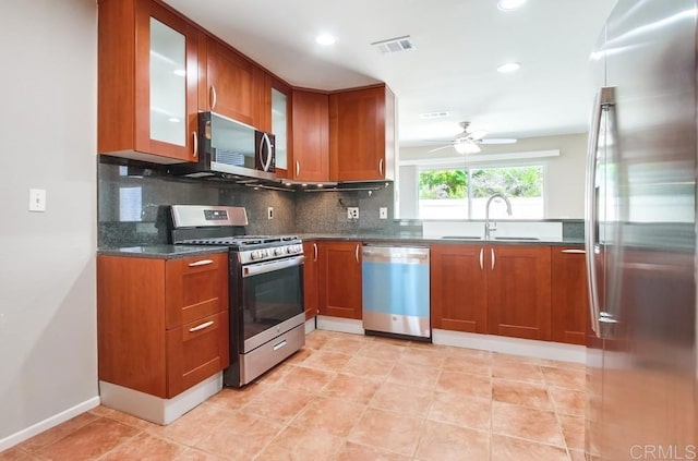 4620 Los Alamos Way Unit C, Oceanside, CA 92057 - kitchen with stainless steel appliances, a ceiling fan, backsplash, brown cabinetry, and recessed lighting