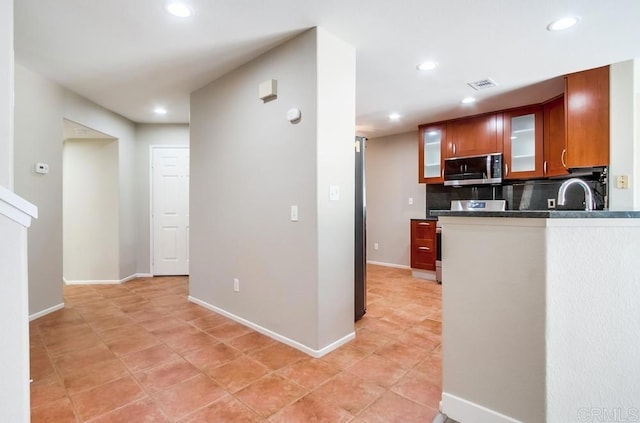 4620 Los Alamos Way Unit C, Oceanside, CA 92057 - kitchen featuring appliances with stainless steel finishes, recessed lighting, tasteful backsplash, glass insert cabinets, and brown cabinetry