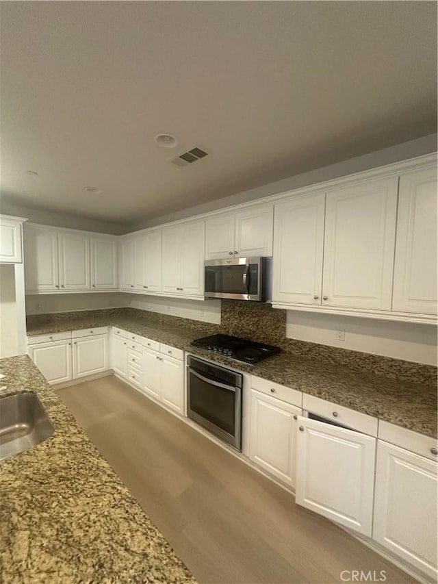 4974 S Rosemary Way, Ontario, CA 91762 - kitchen with stainless steel appliances, white cabinetry, and dark stone counters