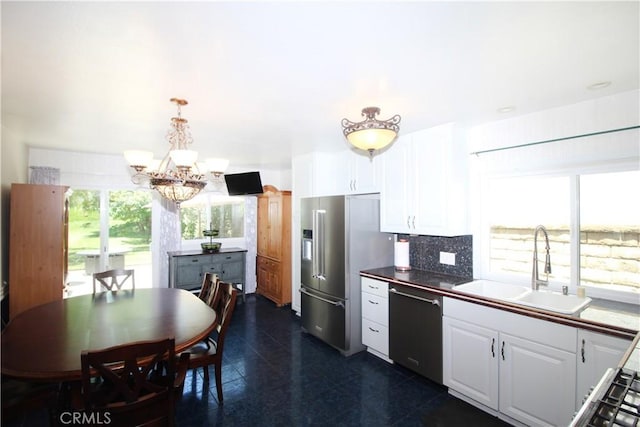 23281 Via Bahia, Mission Viejo, CA 92691 - kitchen with appliances with stainless steel finishes, white cabinetry, a chandelier, and decorative backsplash