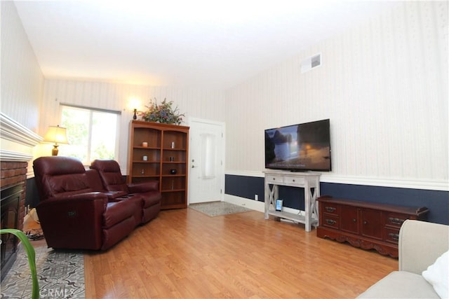 23281 Via Bahia, Mission Viejo, CA 92691 - living room featuring wallpapered walls, a brick fireplace, wood finished floors, and a wainscoted wall