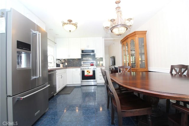 23281 Via Bahia, Mission Viejo, CA 92691 - kitchen featuring appliances with stainless steel finishes, a chandelier, white cabinetry, decorative backsplash, and granite tiled floors