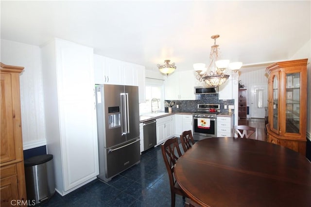 23281 Via Bahia, Mission Viejo, CA 92691 - kitchen featuring appliances with stainless steel finishes, a chandelier, white cabinetry, backsplash, and decorative light fixtures