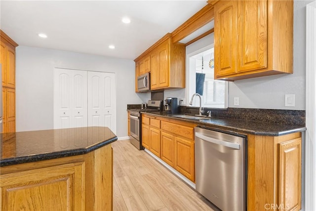 2951 S Plainfield Pl, Ontario, CA 91761 - kitchen with stainless steel appliances, light wood-style floors, dark stone counters, brown cabinetry, and recessed lighting