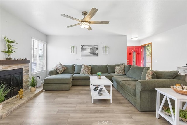 2951 S Plainfield Pl, Ontario, CA 91761 - living area with a ceiling fan, light wood-style floors, and a stone fireplace