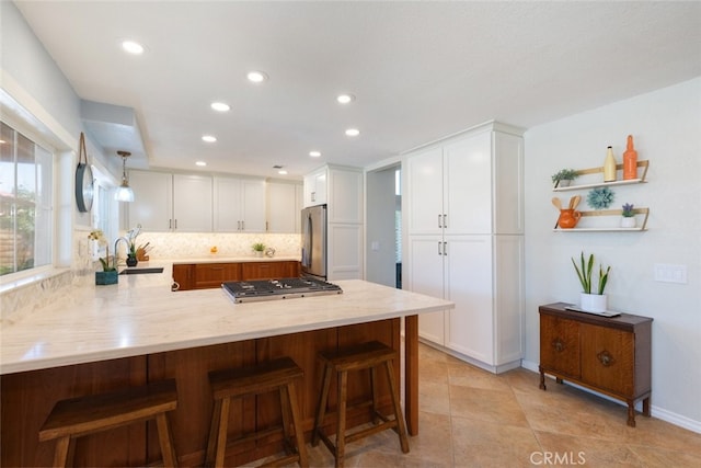 1225 Old Hickory Rd, Corona, CA 92882 - kitchen with a peninsula, stainless steel appliances, white cabinetry, recessed lighting, and a breakfast bar area
