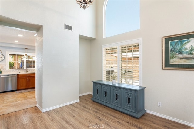 1225 Old Hickory Rd, Corona, CA 92882 - hall with a chandelier, light wood-style floors, and a towering ceiling
