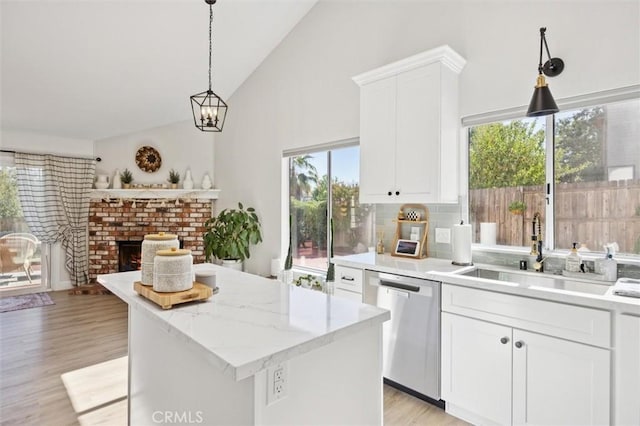 215 Meadowlark Rd, Paso Robles, CA 93446 - kitchen featuring stainless steel dishwasher, a center island, white cabinets, a brick fireplace, and high vaulted ceiling