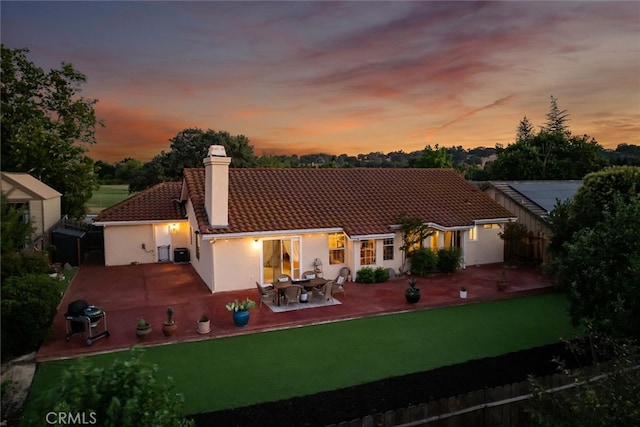 215 Meadowlark Rd, Paso Robles, CA 93446 - back of property at dusk featuring a tile roof, a chimney, a patio, and stucco siding