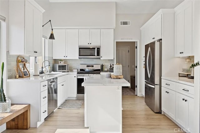 215 Meadowlark Rd, Paso Robles, CA 93446 - kitchen with stainless steel appliances, light wood-type flooring, tasteful backsplash, and white cabinets