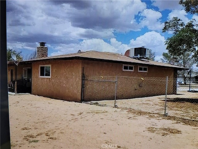 15420 Apache Rd, Apple Valley, CA 92307 - view of side of home featuring a chimney and stucco siding