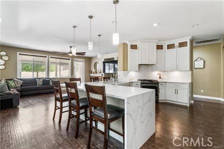 11126 Whitebark Ln, Corona, CA 92883 - kitchen with range with electric stovetop, a breakfast bar area, open floor plan, hanging light fixtures, and a peninsula