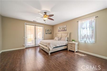 11126 Whitebark Ln, Corona, CA 92883 - bedroom with multiple windows, access to outside, wood finished floors, and french doors
