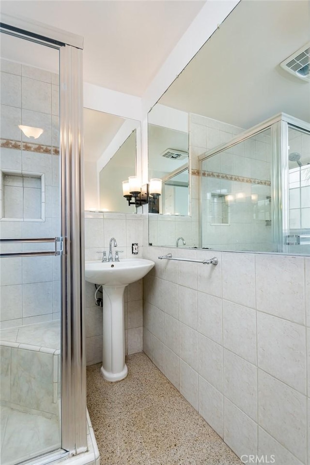 11162 Barman Ave, Culver City, CA 90230 - bathroom featuring speckle patterned floor, a shower stall, and tile walls