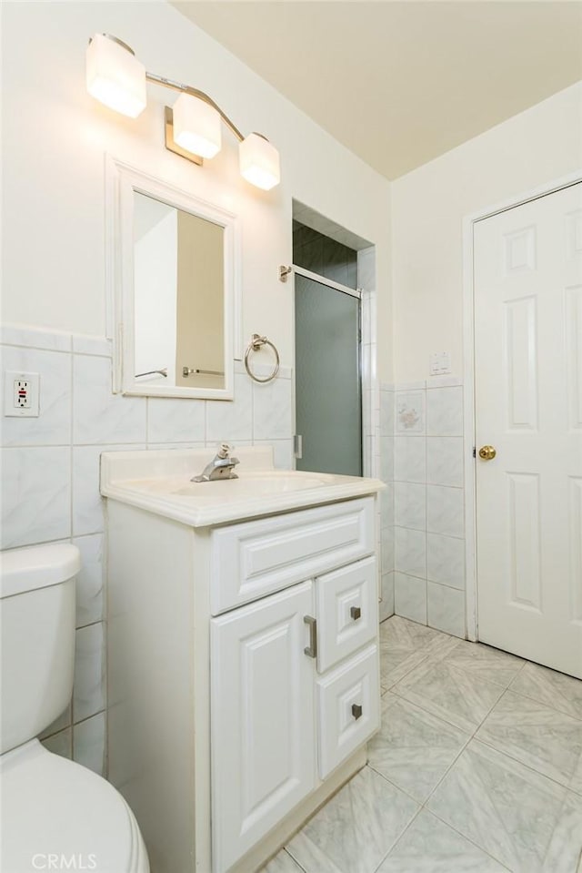 11162 Barman Ave, Culver City, CA 90230 - bathroom with tile walls, vanity, a shower with door, and wainscoting