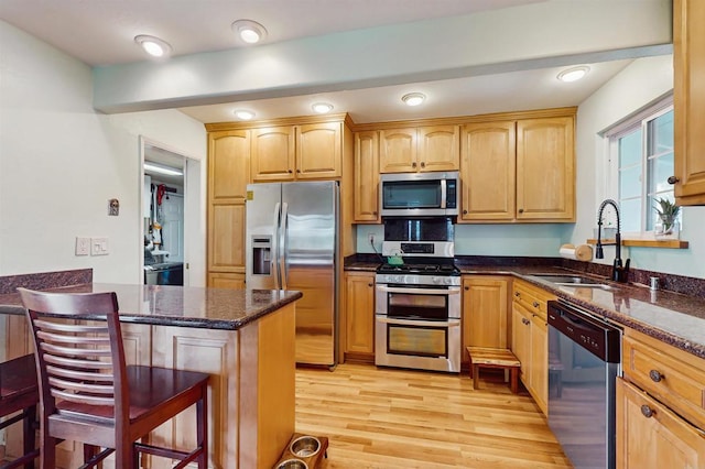 12538 Buckskin Trl, Poway, CA 92064 - kitchen featuring appliances with stainless steel finishes, dark stone counters, light wood-style flooring, and a kitchen bar