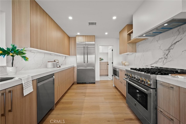 2115 E Santiago St, Covina, CA 91724 - kitchen with high end appliances, wall chimney range hood, modern cabinets, backsplash, and light countertops