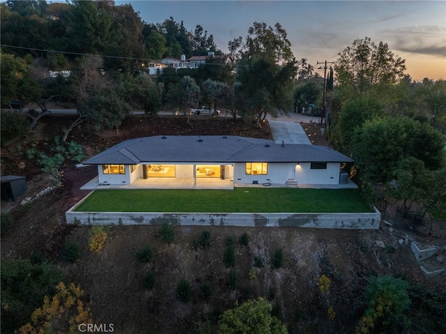 2115 E Santiago St, Covina, CA 91724 - back of house at dusk with a yard, a patio area, and view of wooded area