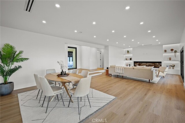 2115 E Santiago St, Covina, CA 91724 - dining area with light wood-style flooring, recessed lighting, and a glass covered fireplace