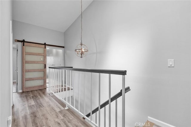 1346 Tourney Hill Ln Unit 67, Nipomo, CA 93444 - hall featuring an upstairs landing, a barn door, wood finished floors, a chandelier, and lofted ceiling