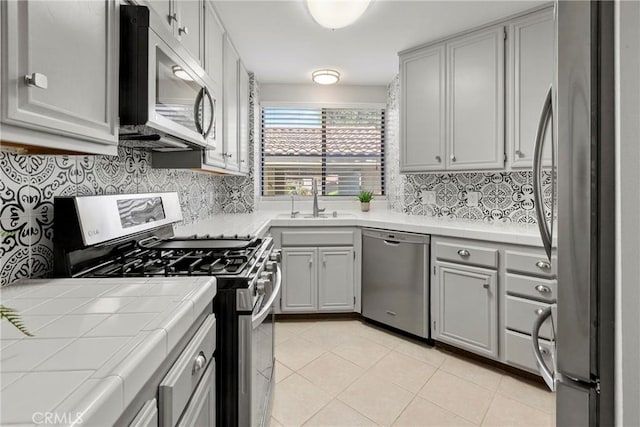 1346 Tourney Hill Ln Unit 67, Nipomo, CA 93444 - kitchen featuring stainless steel appliances, tile countertops, tasteful backsplash, light tile patterned floors, and gray cabinetry