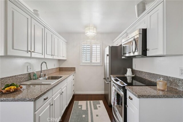 2704 Voorhees Ave Unit 4, Redondo Beach, CA 90278 - kitchen with stainless steel appliances, white cabinetry, dark wood-type flooring, a chandelier, and dark countertops