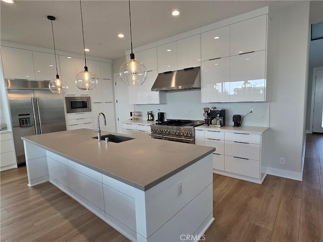 171 Bear Leaf Dr, Lake Forest, CA 92630 - kitchen featuring exhaust hood, built in appliances, modern cabinets, light wood-style flooring, and white cabinetry