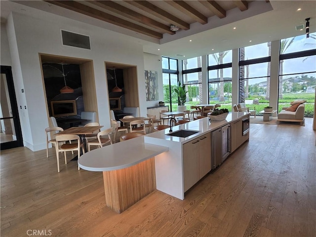 171 Bear Leaf Dr, Lake Forest, CA 92630 - kitchen with open floor plan, a spacious island, light countertops, beam ceiling, and light wood finished floors