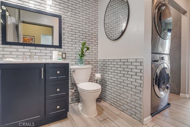 488 E Ocean Blvd Unit 502, Long Beach, CA 90802 - bathroom featuring stacked washing machine and dryer, vanity, wood tiled floors, and tile walls