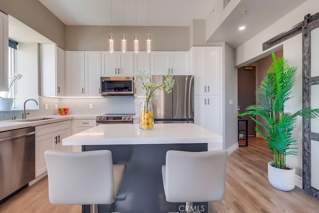 488 E Ocean Blvd Unit 502, Long Beach, CA 90802 - kitchen featuring stainless steel appliances, a kitchen island, decorative backsplash, a breakfast bar area, and light wood-type flooring