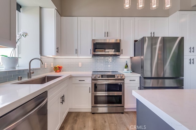 488 E Ocean Blvd Unit 502, Long Beach, CA 90802 - kitchen with appliances with stainless steel finishes, tasteful backsplash, light wood-style floors, and white cabinets