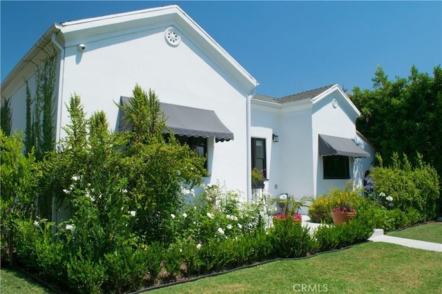 542 N Kilkea Dr, Los Angeles, CA 90048 - view of property exterior with stucco siding and a lawn