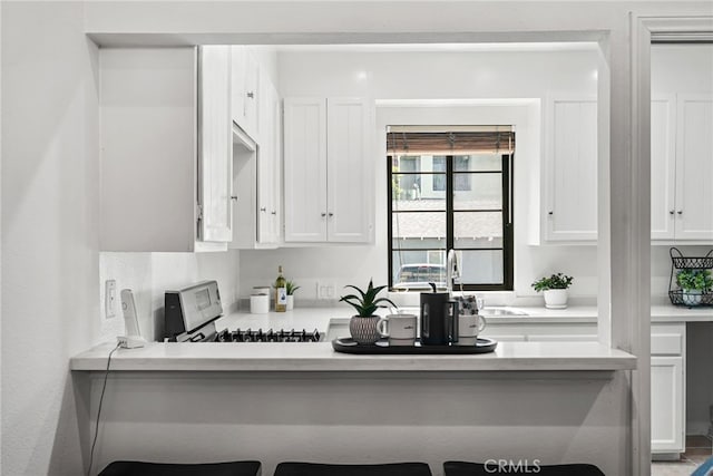 1737 Peyton Ave Unit E, Burbank, CA 91504 - kitchen featuring stainless steel range oven, white cabinets, light countertops, and a breakfast bar